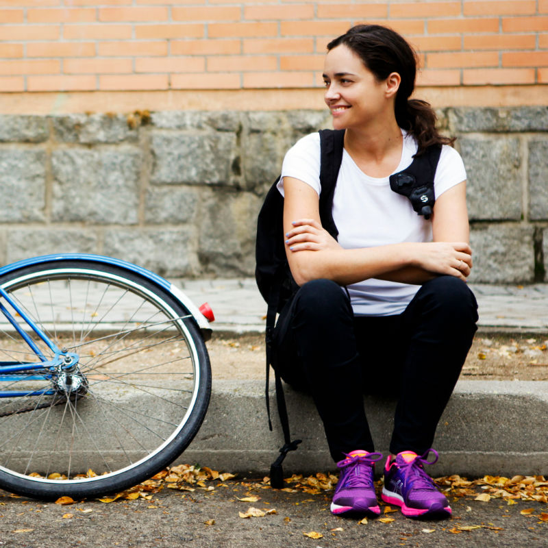 Una joven junto a su bicicleta