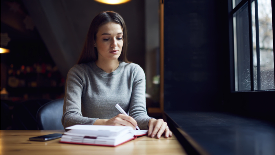 Estudiar una maestría profesional; una joven estudia sola con libros