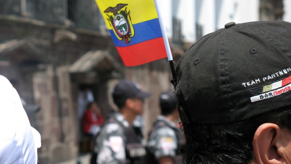 Bandera del Ecuador y de fondo policías 