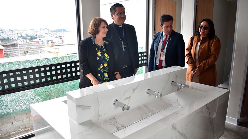 A la izquierda, Rosalía Arteaga, presidenta de UNIR Ecuador, en las nuevas baterías sanitarias del colegio. 