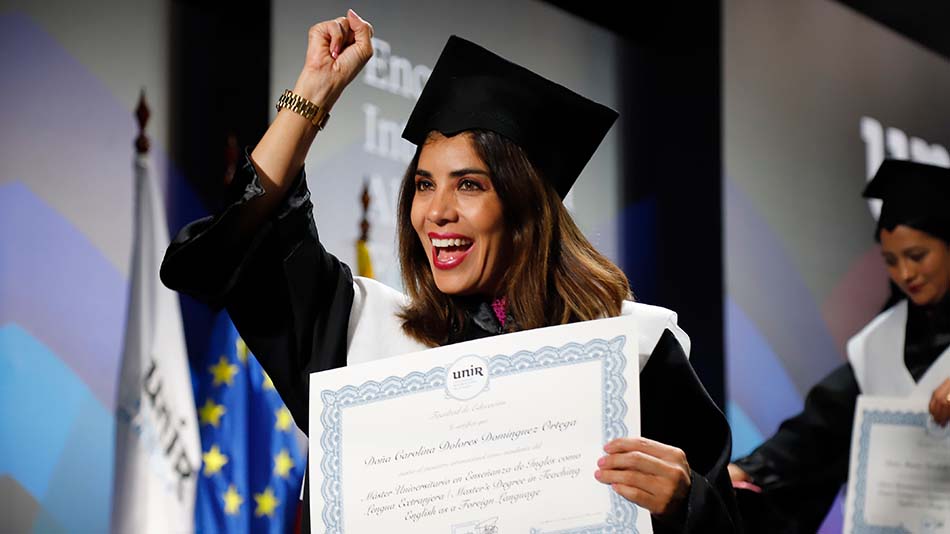 Puño en alto, una alumna expresa su alegría tras recibir su diploma.