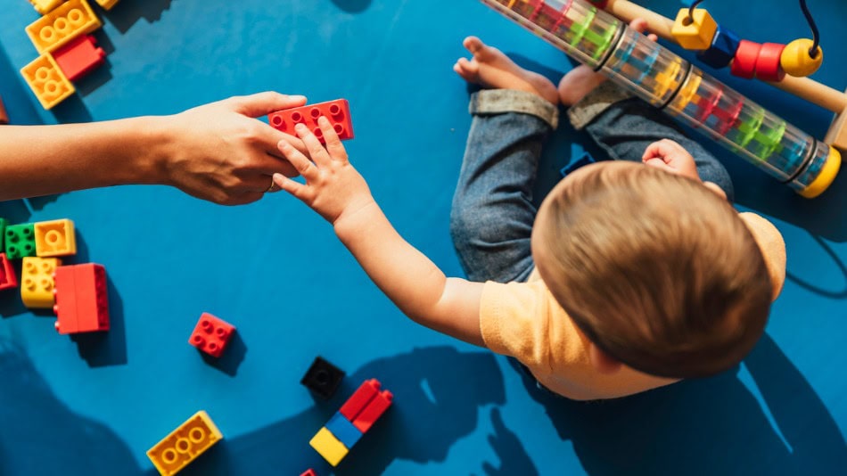 Bebé jugando con bloques clave para la estimulación temprana