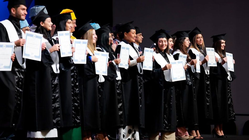 Alumnos muestran orgullosos sus diplomas.